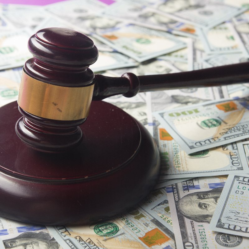 close-up of a judge's gavel on a pile of money