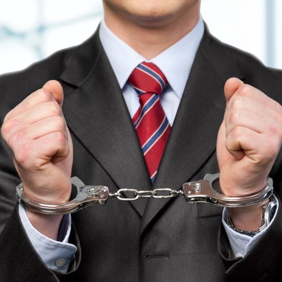 Man with suit in handcuffs