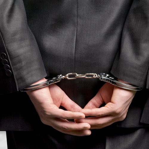 A Man in a Business Suit Is Handcuffed.