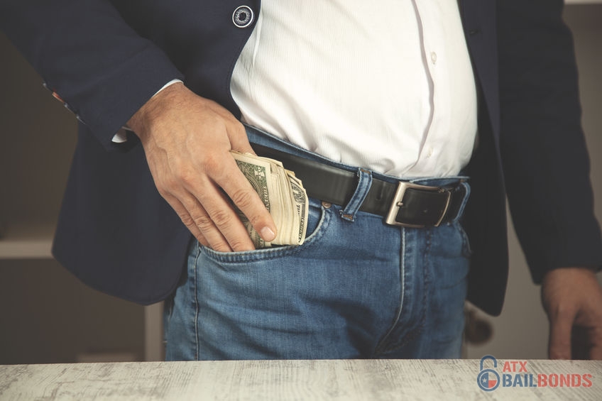 Businessman's Hand Putting Money in Pocket